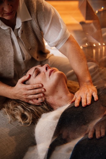 Hridaya cradling a participant's head in session
